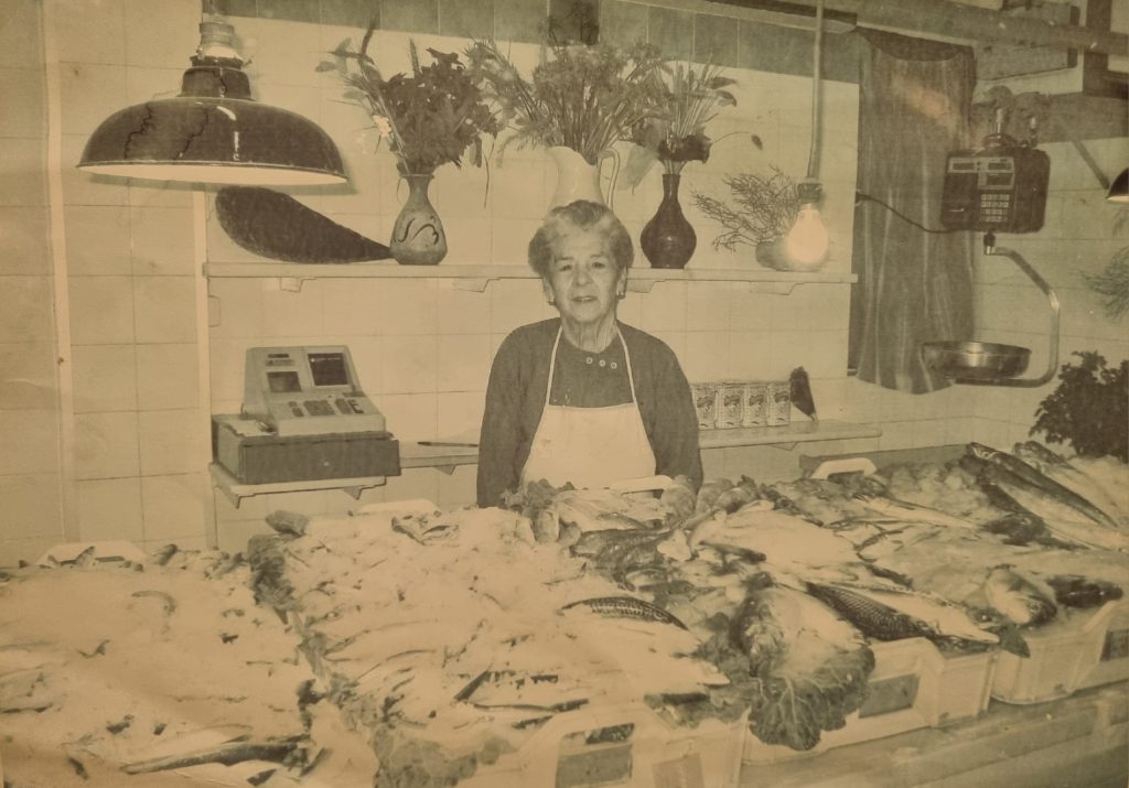 Señora mayor regentando una pescadería en una foto en blanco y negro